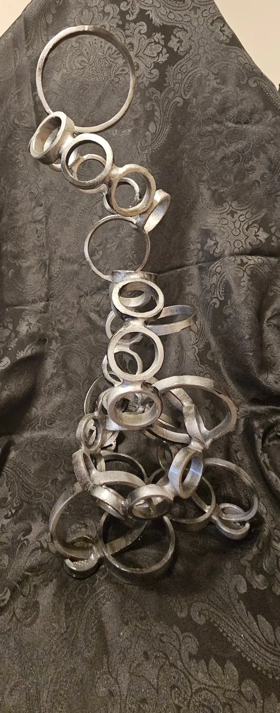 A tall metal sculpture of rings on top of a table.