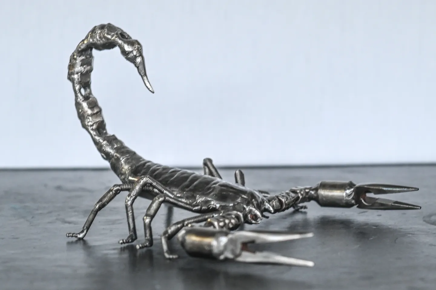 A metal scorpion sculpture sitting on top of a table.