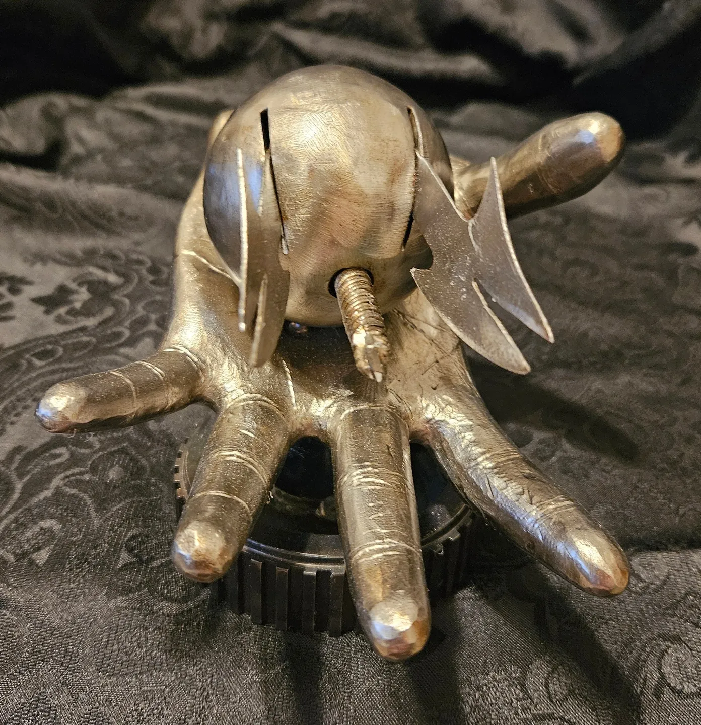 A metal sculpture of an elephant with two scissors in it's hand.