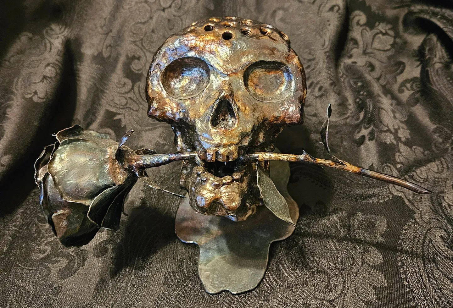 A metal skull with a stick in its mouth.