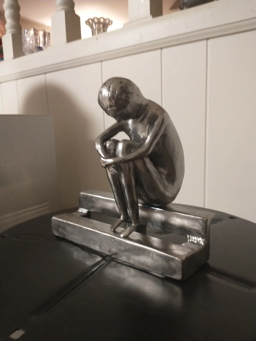 A statue of a person sitting on top of a table.