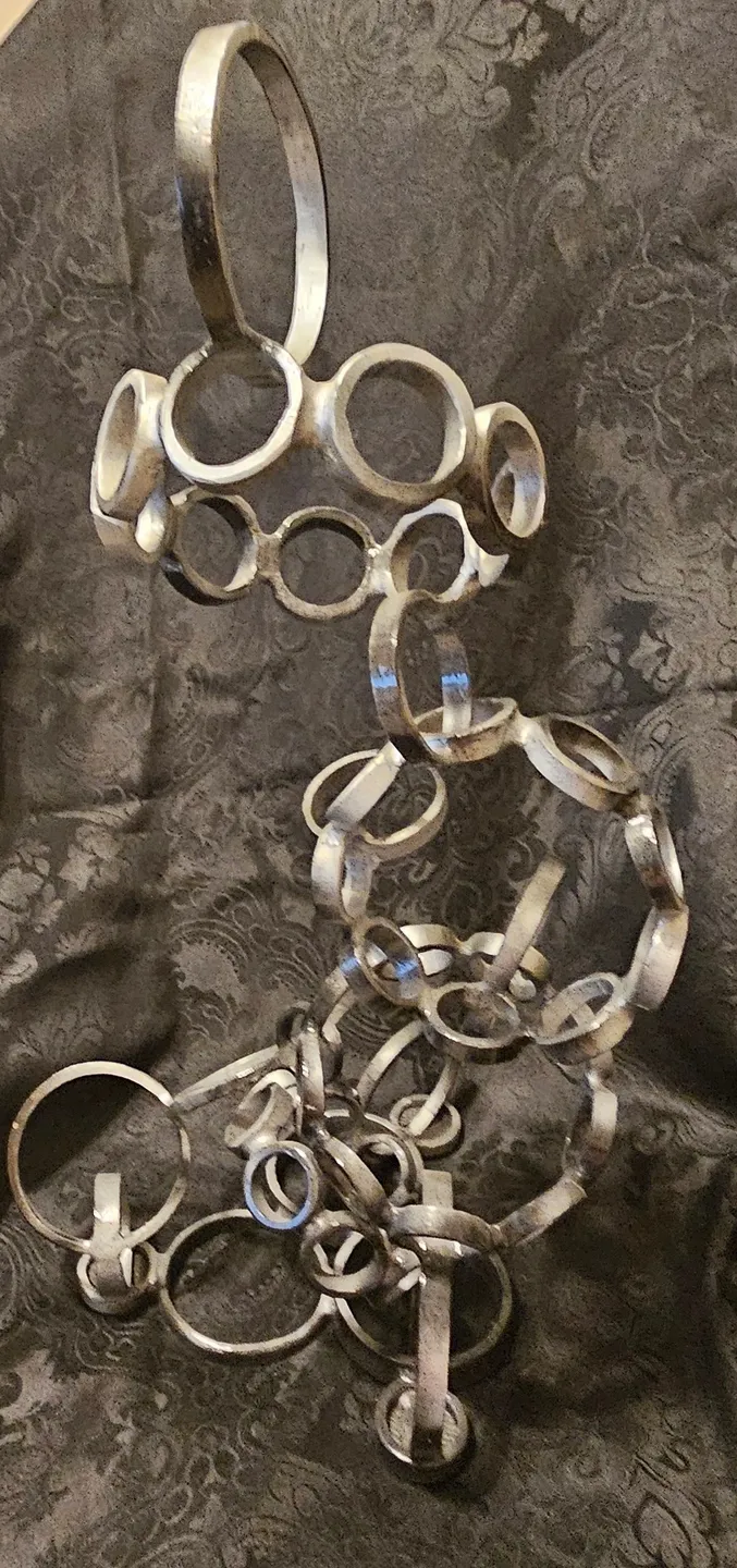 A metal sculpture of rings on top of a table.