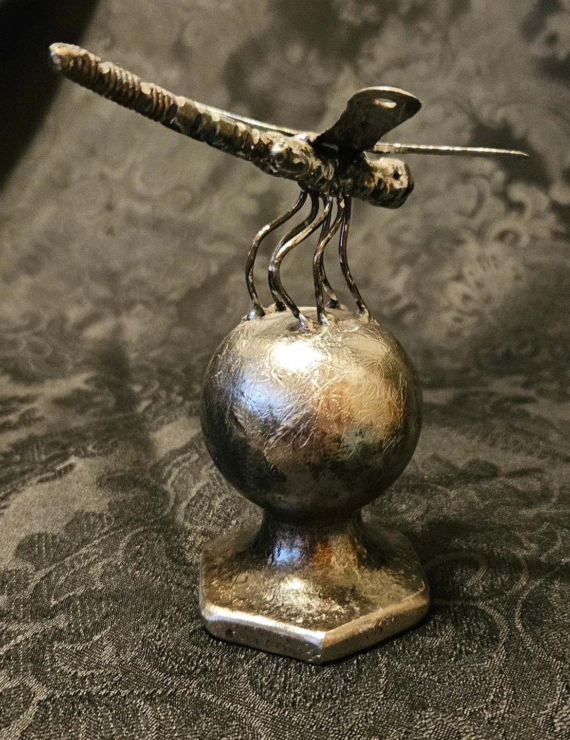 A metal object with a stick on top of it.