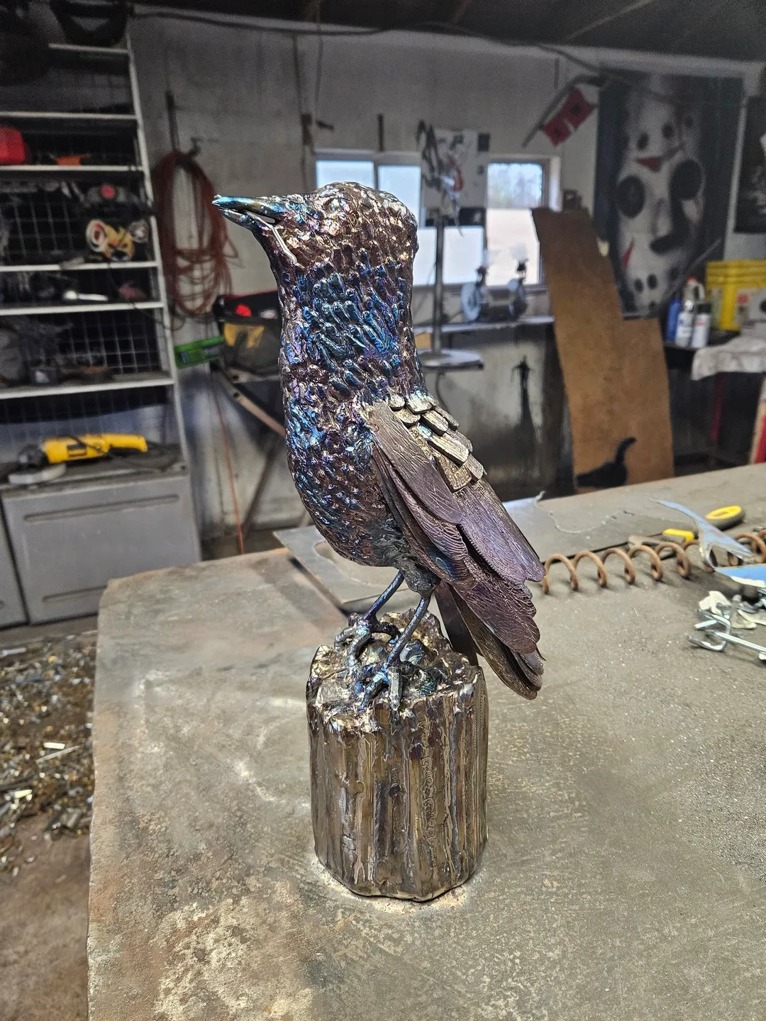 A bird statue sitting on top of a wooden block.