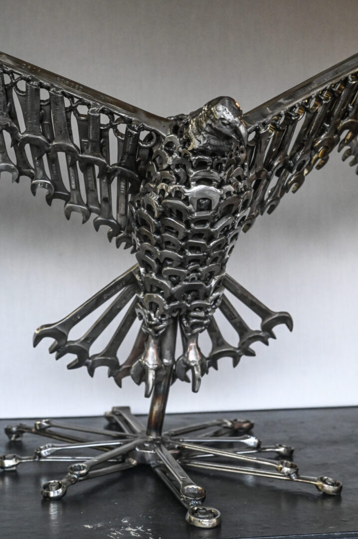 A metal sculpture of an eagle made out of wrenches.