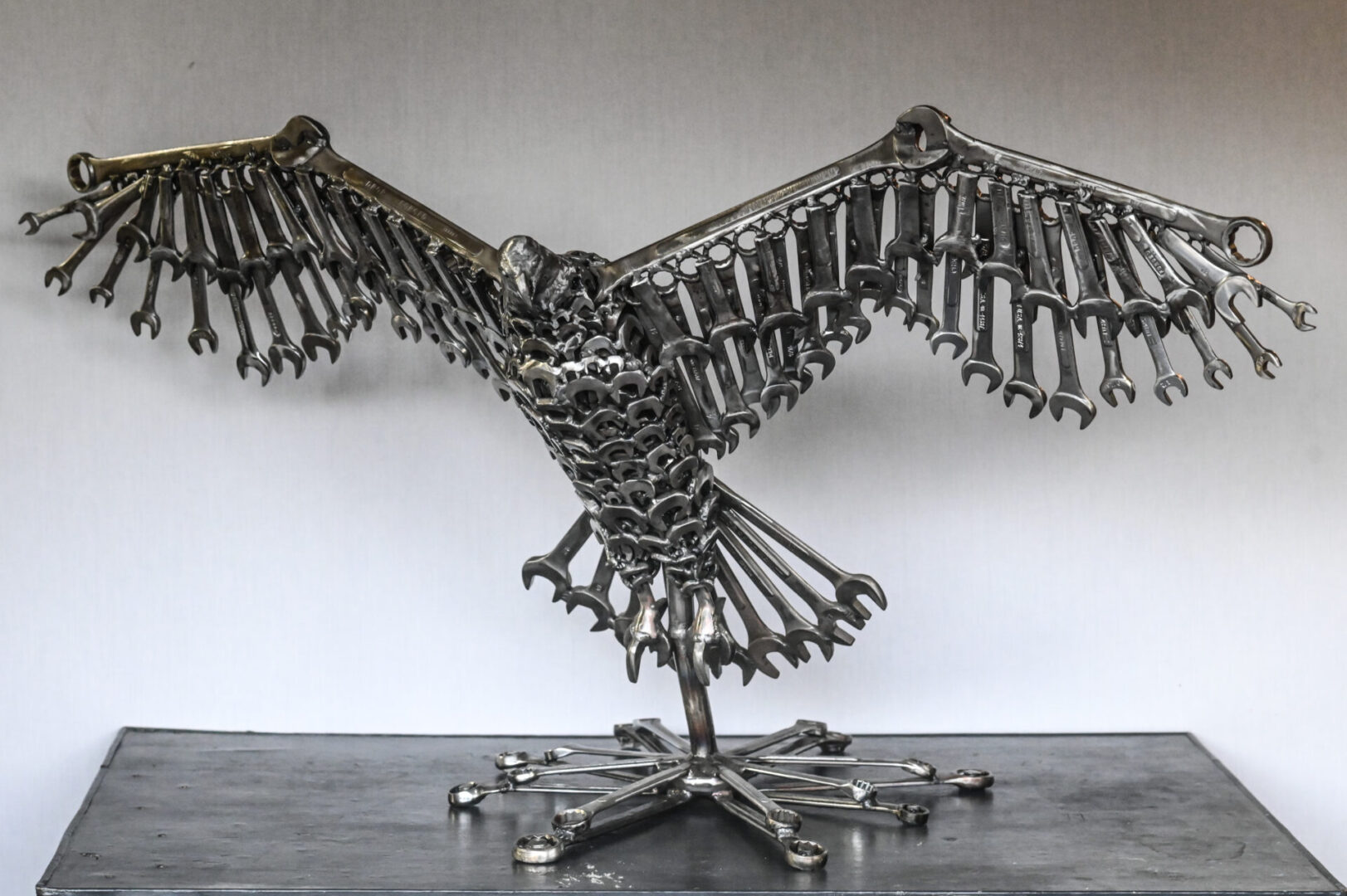 A metal sculpture of an eagle made out of wrenches.