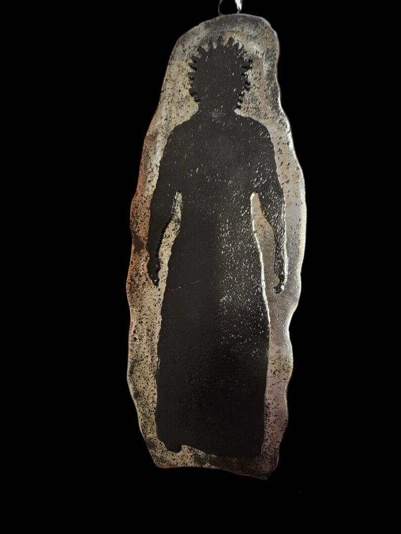 Silhouette of a person on metal pendant.