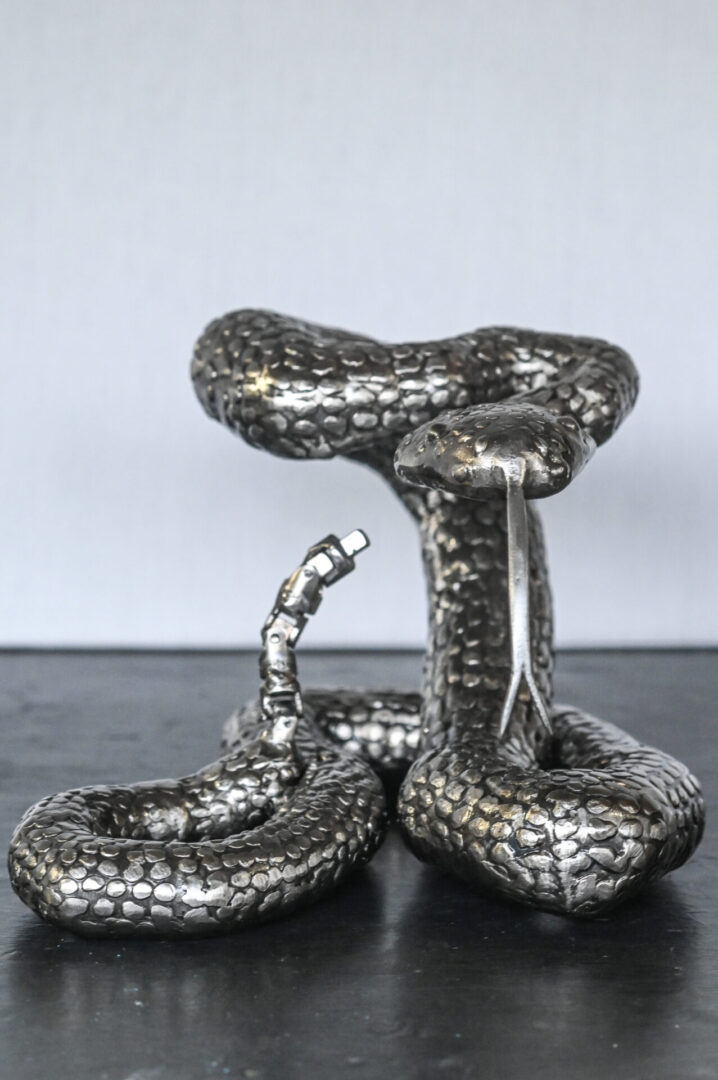 A silver snake statue sitting on top of a table.