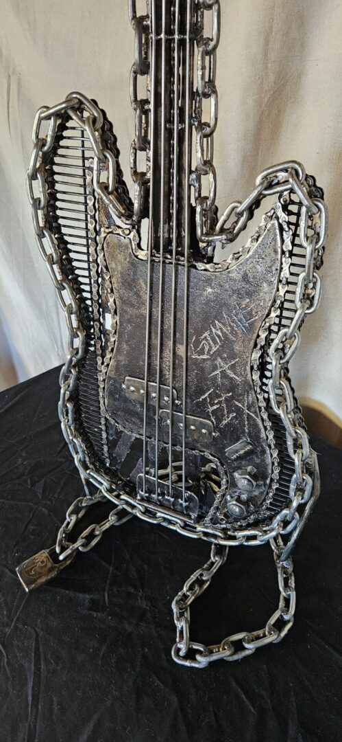 Metal sculpture of a bass guitar.