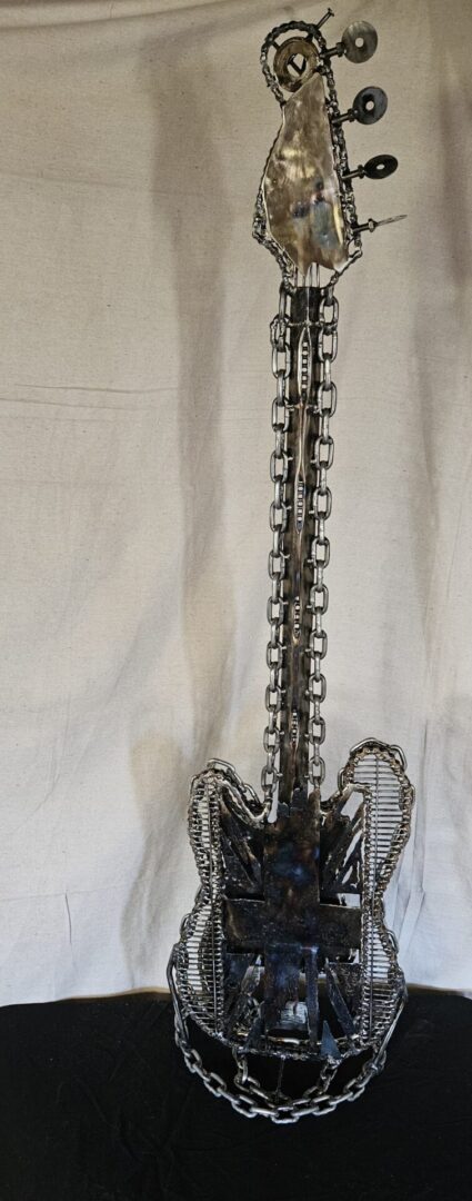 Metal sculpture of a guitar made of chains.