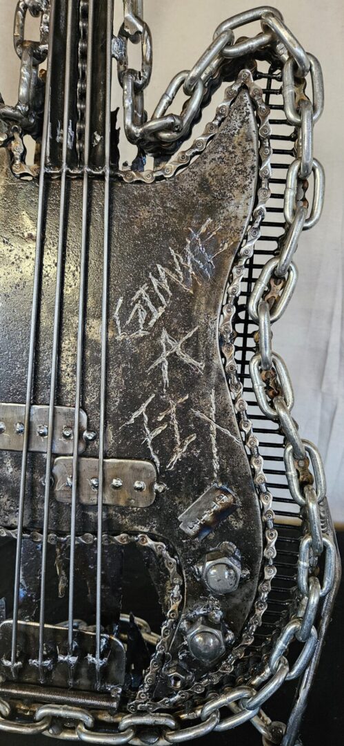 Metal sculpture of a bass guitar.